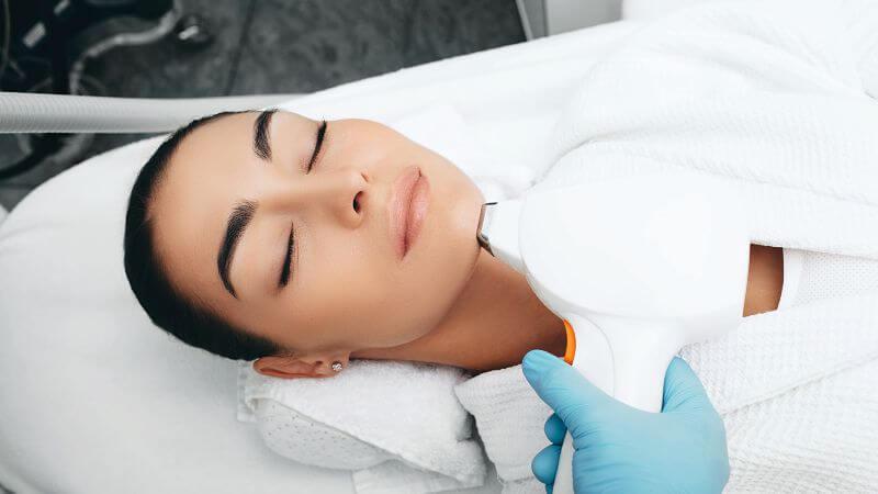 woman lying down with eyes closed having laser hair removal on chin – What Is A Small Area For Laser Hair Removal