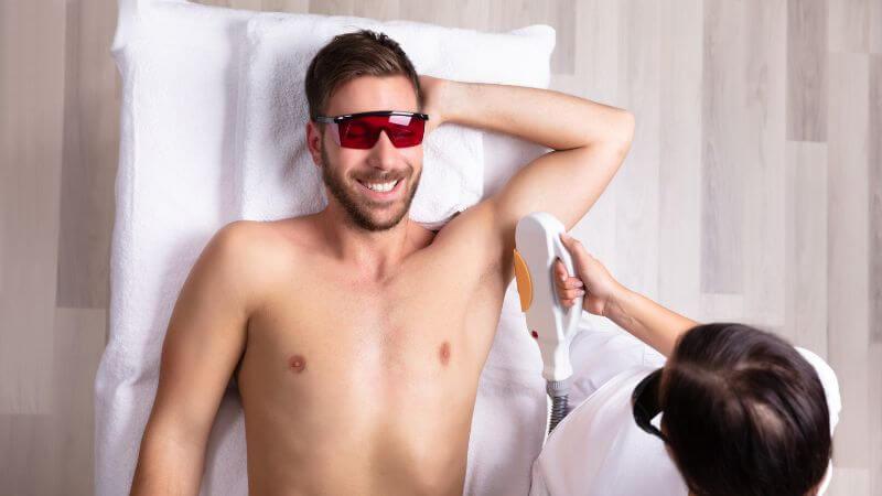 man lying down having laser hair removal on underarm – What Is A Small Area For Laser Hair Removal