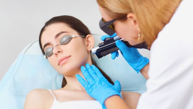 dermatologist checking the mole on the woman's neck