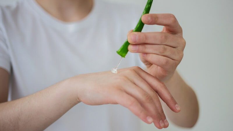woman applying aloe vera gel on her hand - can you get laser hair removal with acne
